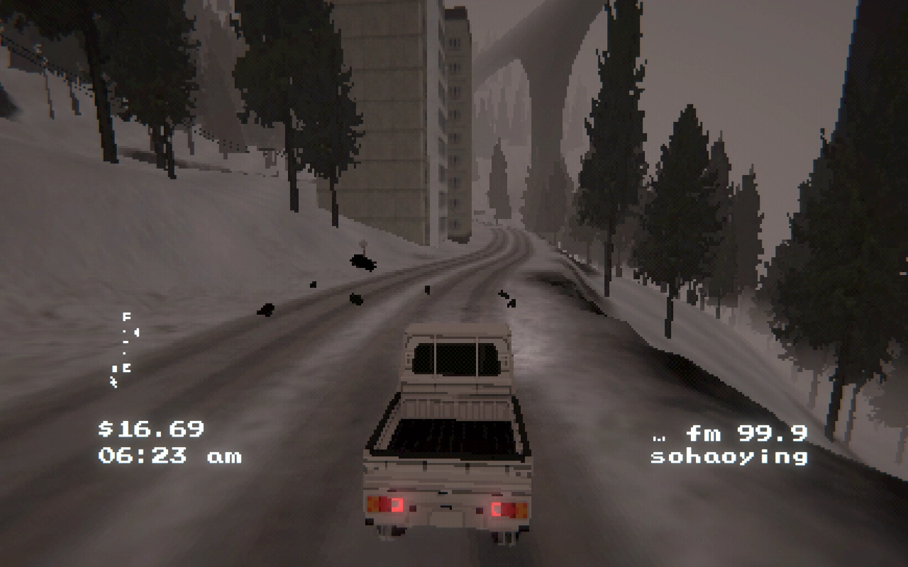 A car is driving through a snow filled path with trees, buildings and a high bridge in the back.